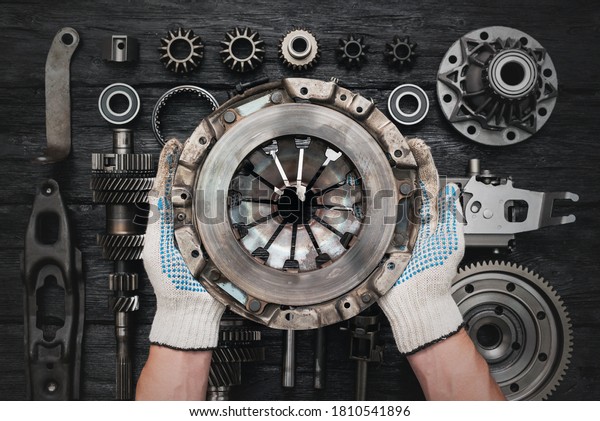 Old car clutch basket in auto service worker hands
close up.