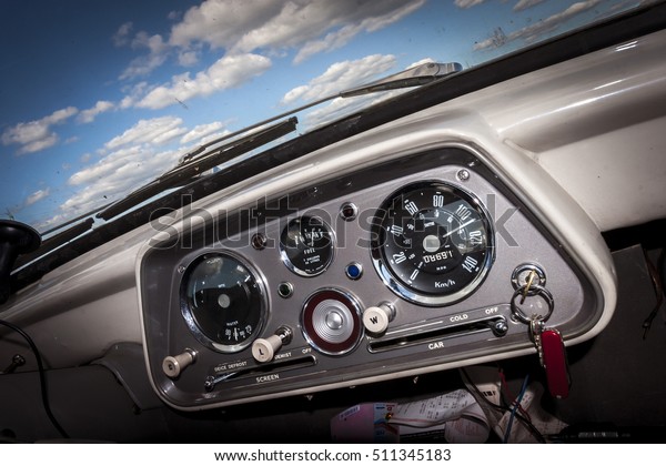 Old Car Dashboard. Retro British Auto Interior\
Detail with Blue Sky and\
Clouds.