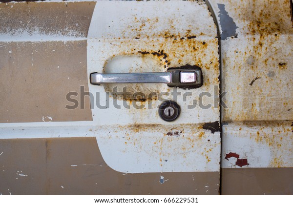 Old car door have rust.Door handle of old\
car.vintage and retro background.paint metal wall rusty metal\
background with streaks of rust\
stains
