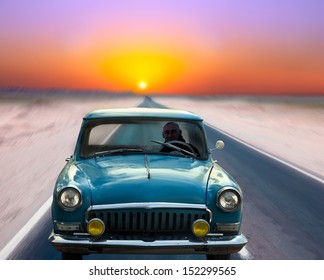 Old Car Driving On The Road At Dusk