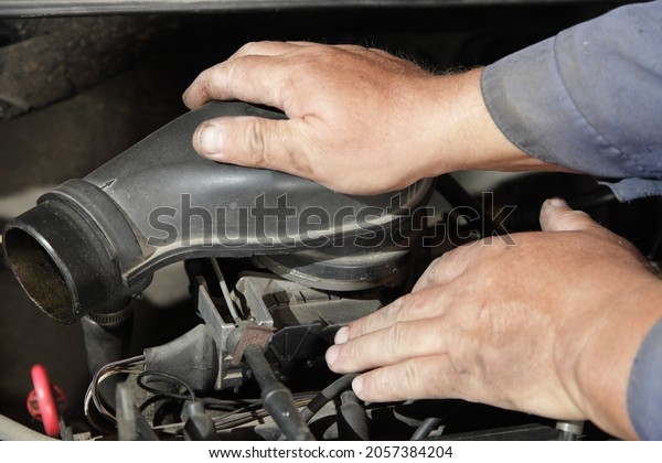 Old car engine air filter check - service man\
hands holding the air filter box on mono injector fuel system unit\
closeup, motor repair\
service