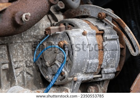 Old car engine alternator rust covered with duct tape blue wire