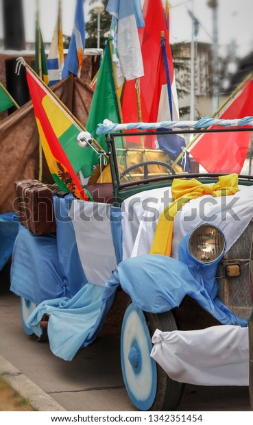 Old car with flags, concept of\
immigration in different countries. suitcases,\
flags,