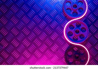 Old car gear wheels in the neon lights flat lay abstract background with copy space.