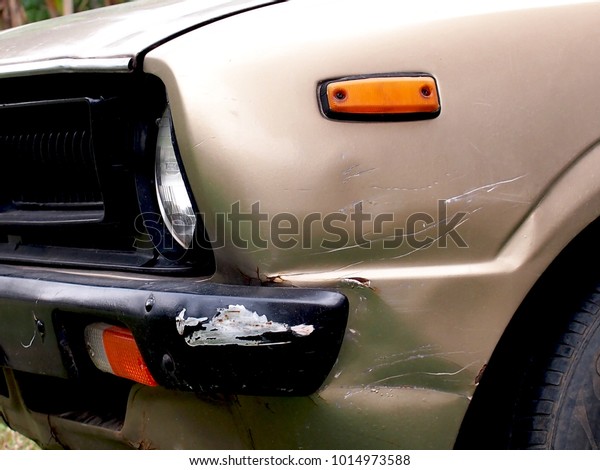 The old car has a\
dents from the collision.