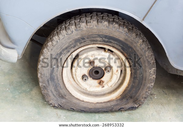 old car with leak out\
damage tire