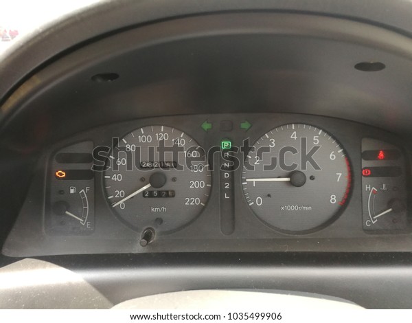 Old\
car meter in the car.  light engine on the car\
meter