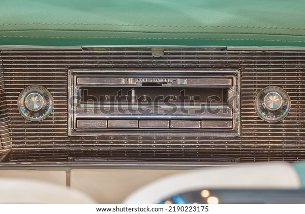 Old car radio inside a green classic American\
car with chrome dashboard