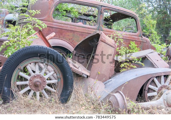 Old car in scrap\
metal stack. Old Wheel.