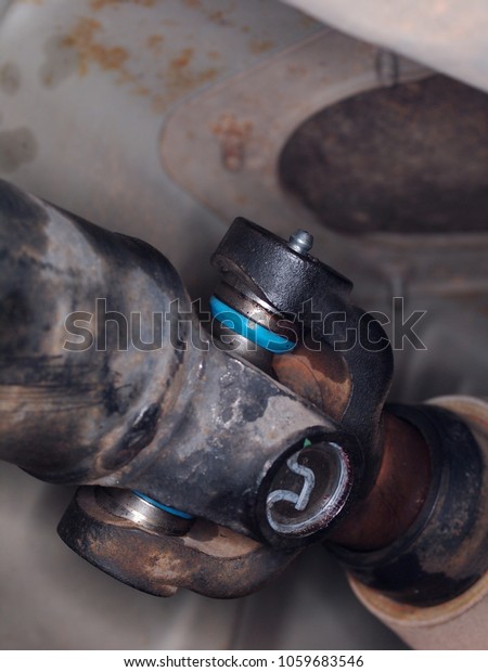 old car sport utility vehicle\
automobile drive shaft with new universal joint replacement\
installed selective focus on the new parts blur authentic\
background 