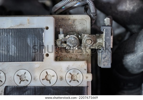 Old car\
starter battery inside the engine bay viewed from above top down,\
negative terminal connection\
closeup