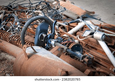 An old car steering wheel lies in a pile of rusty scrap metal. Car recycling concept. Close up. No people. - Powered by Shutterstock