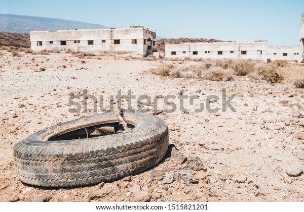 old car tire dumped\
in desert landscape
