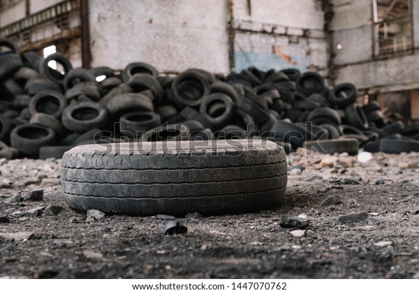 old car tire lying on the ground of an\
abandoned factory compared to other\
tires.