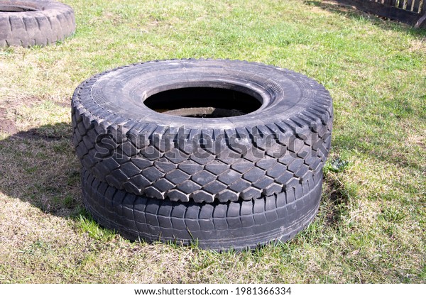 Old car tires from a heavy truck. Truck tires\
are stacked.