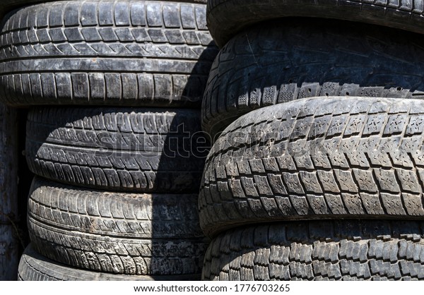 Old car tires stacked in\
piles