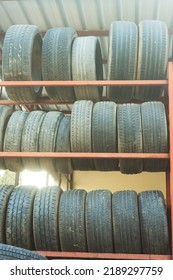 Old Car Tires Under The Roof. Warehouse Of An Old Tire Garage. Used Car Tires