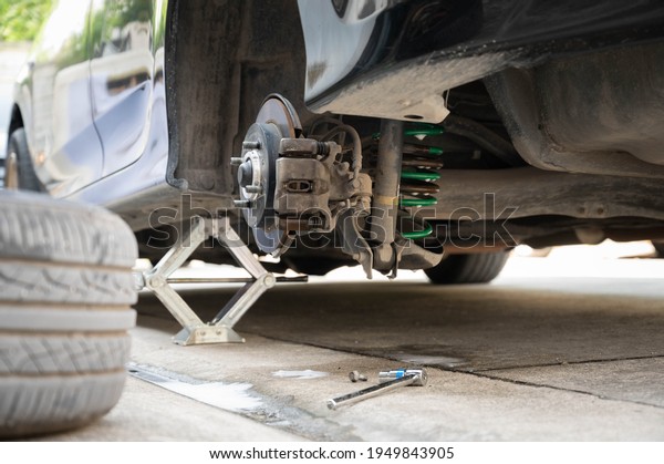 Old car use a car jack to remove the wheel to\
change a spare wheel or brake\
pads