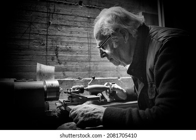 Le vieux charpentier travaille sur un tour. Photo en noir et blanc en gros plan