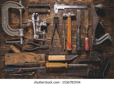 Old carpentry work tools on a brown wooden table background.