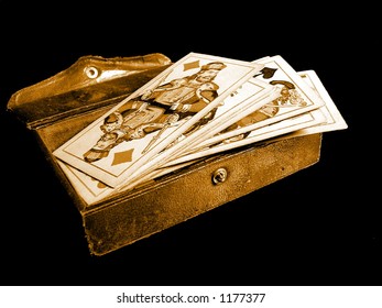 Old casino cards and card-box on black background.