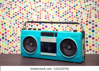 Old cassette tape recorder turquoise color on a multi-colored background
