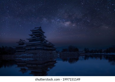 Old castle in japan. Matsumoto castle against night sky. Castle in Winter with milky way on sky .Travel Matsumoto Castle with frozen pond in Winter. A Japanese premier historic castles	

