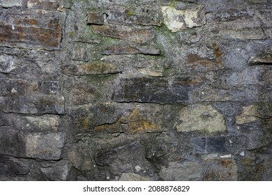 Old castle wall, cracked stonework. Background from stones and cement mortar.