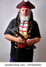 Old Caucasian male dressed in a pirate costume expressing himself with antique flintlock weapon. 