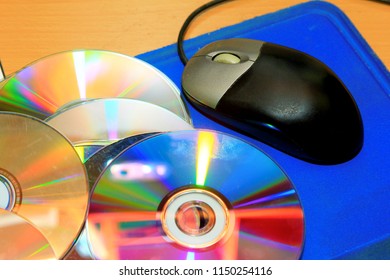 Old CD And Computer Mouse With A Blue Mouse Pad