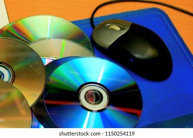 Old CD And Computer Mouse With A Blue Mouse Pad