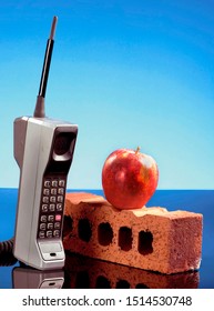Old Cell Phone Called The Brick Phone With A Red Apple Made In The Early 1980's.