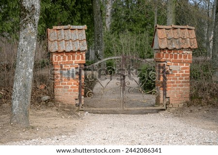old cemetery gate with pylons made of red bricks. Lielplatones kapi, Latvia.