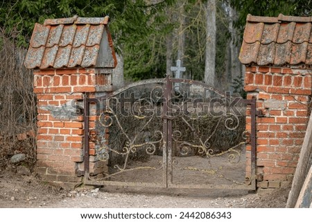 old cemetery gate with pylons made of red bricks. Lielplatones kapi, Latvia.