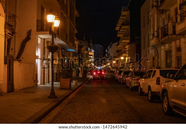 Old center Batumi. The old Batumi street is\
parked by cars in the\
evening.