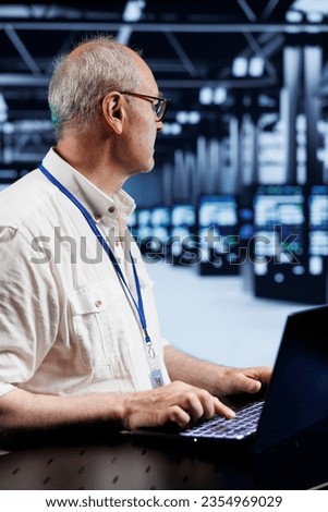 Old certified IT programmer in data center providing dedicated VPN servers able to deliver enhanced privacy, encrypted sensitive data, online anonymity and reliable internet connections to users