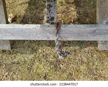 An Old Chain With Rust On One End Attached To A Board.