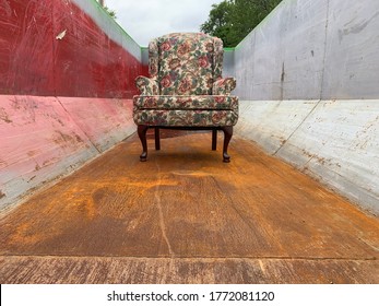 Old Chair Sitting In An Empty Dumpster. Used Furniture Disposal Concept