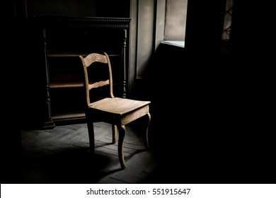 Old Chair Standing In A Dark Room Near The Window, On The Old Floor Beside An Empty Locker.