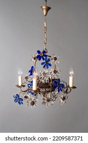 Old Chandelier With Bronze Base And Blue Flowers