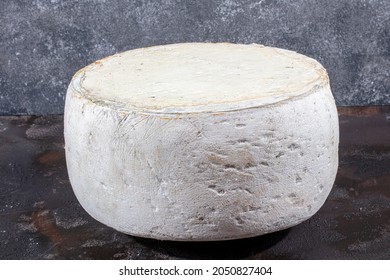 Old Cheddar Cheese. Wheel Aged Cheese. Aged Cheddar Cheese Wheel On Dark Wooden Floor.