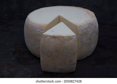 Old Cheddar Cheese. Wheel Aged Cheese. Aged Cheddar Cheese Wheel On Dark Wooden Floor.