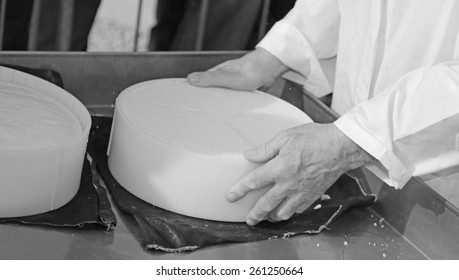 old cheesemaker's hands during the production of cow's milk cheese in the dairy - Powered by Shutterstock