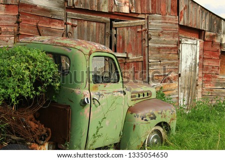 Old Chevy truck in front of old red barn