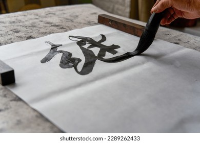 An old Chinese calligrapher is creating and writing calligraphy works.
Translation: carry on the past and open up the future.