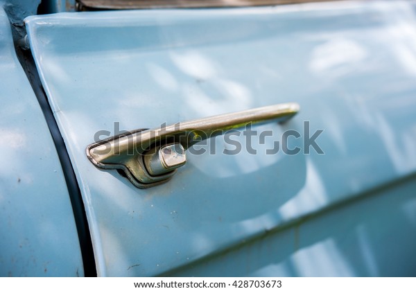 Old chrome car door handle bar close up image on\
rusty body vintage car
