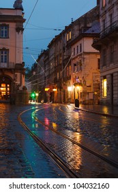 Old City Lviv At Night In Rain With Reflections On Wet Pavement