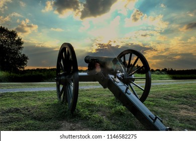 an old Civil War cannon points towards the sunset at Stones River National Battlefield in Murfreesbore Tennessee