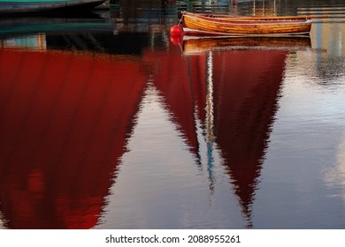 Old Classic Brown Color Varnished Fishing Boat In A River. Old Boat With Red Sail Reflection In Water. Galway City, Ireland. Fine Example Of Old Craft In Show Room Condition.