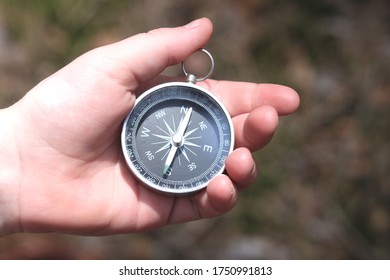 Old classic navigation compass in childs hand on natural background - Shutterstock ID 1750991813